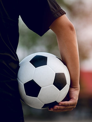 Main qui tient un ballon de foot