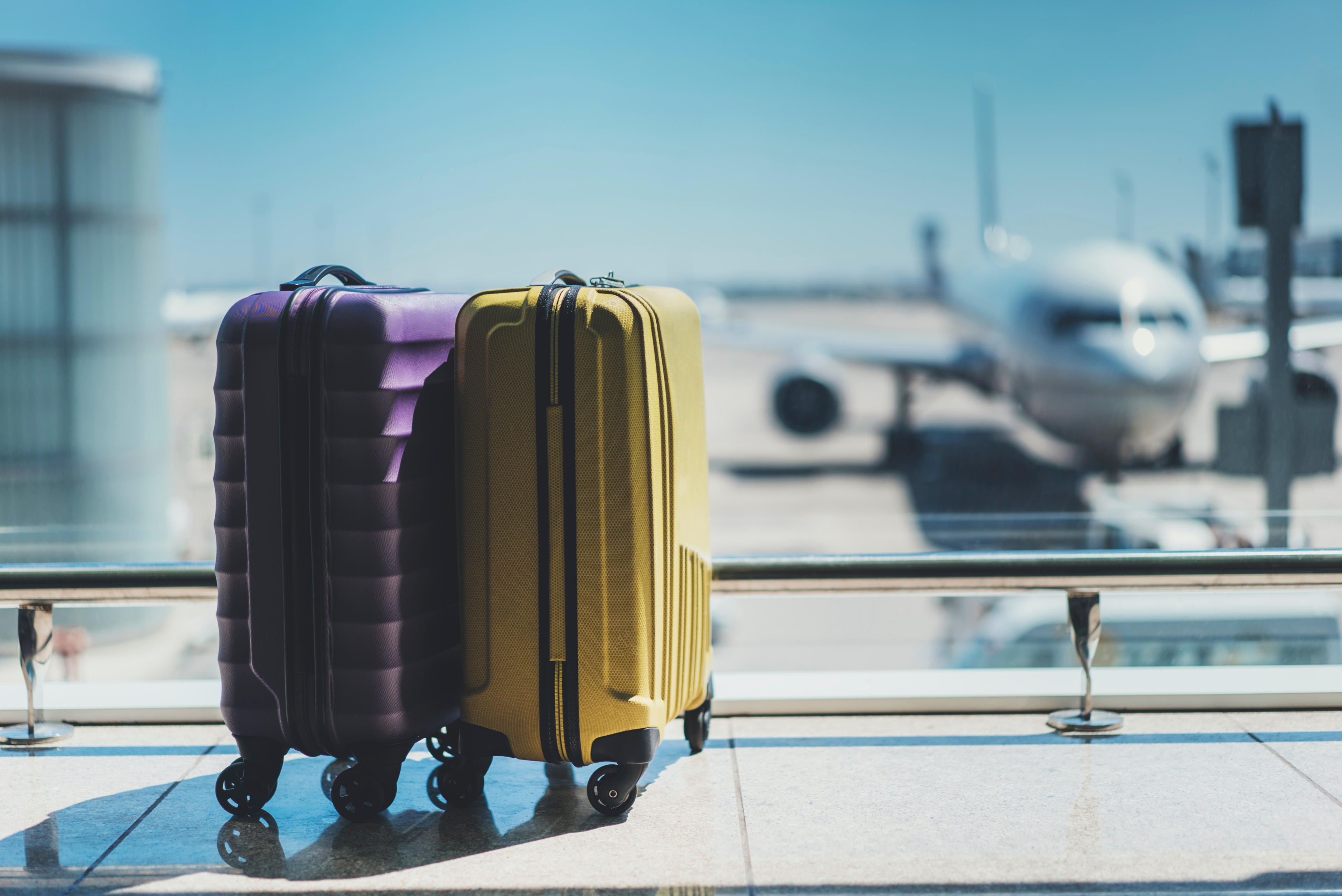 2 valises devant un avion à l'aéroport
