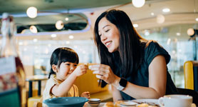 Une mère et sa fille dans un restaurant à l'aéroport