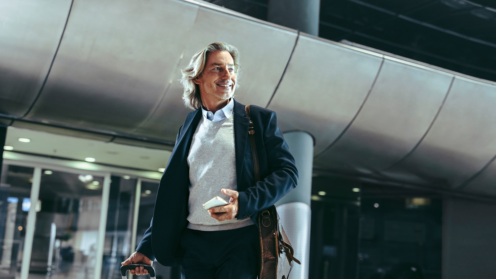 A smiling man in an airport parking lot