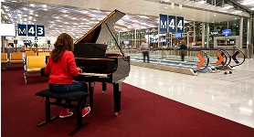 Femme jouant du piano dans le terminal de l'aéroport