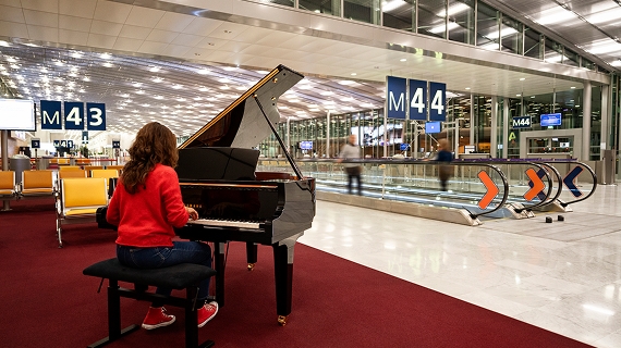 Femme qui joue au piano dans le terminal de l'aéroport