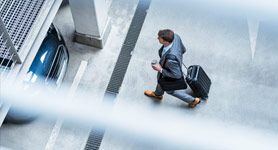 Un homme se rend à son véhicule dans un parking Paris Aéroport